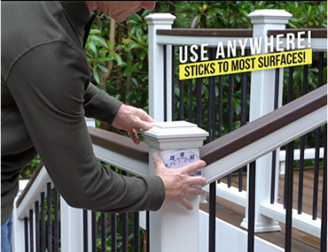 Man attaching light to deck railing with Alien Tape