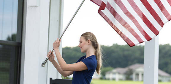 Woman placing an American flag outside